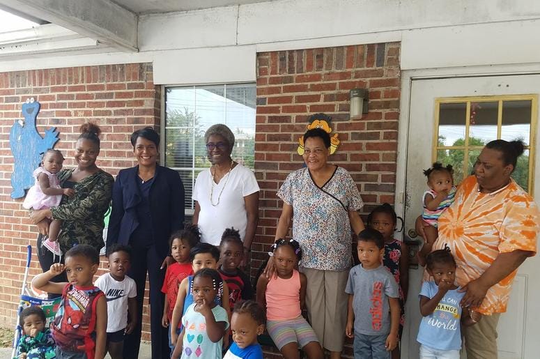 Atlanta Mayor Keisha Lance Bottoms visits with employees and children from the nearby Fun To Learn Daycare Center.